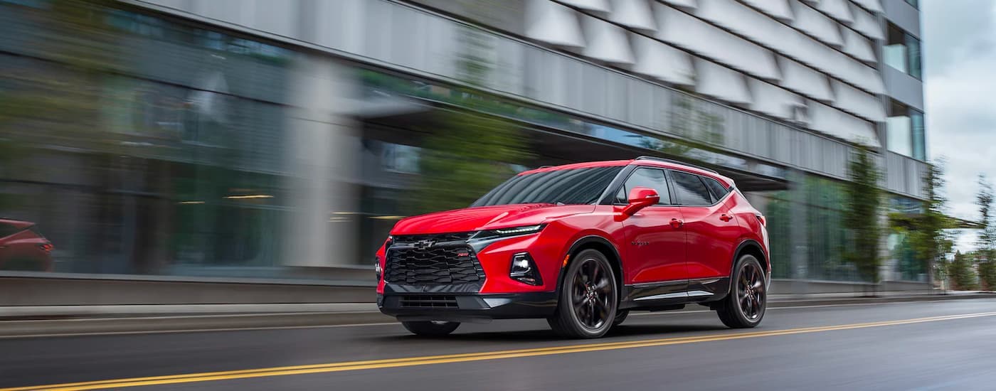 A red 2022 Chevy Blazer RS is shown driving on a city street.