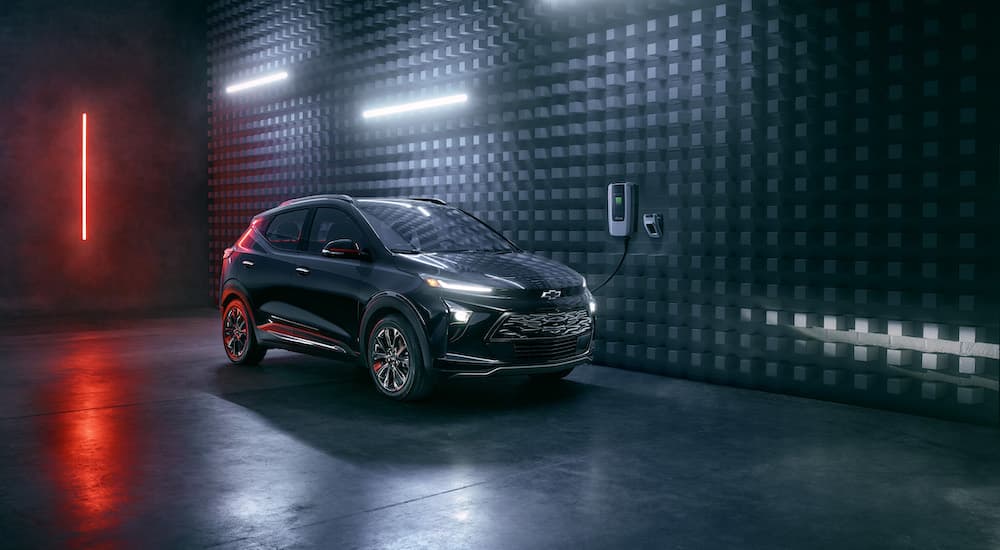 A black 2023 Chevy Bolt EUV Redline Edition charging in a futuristic warehouse