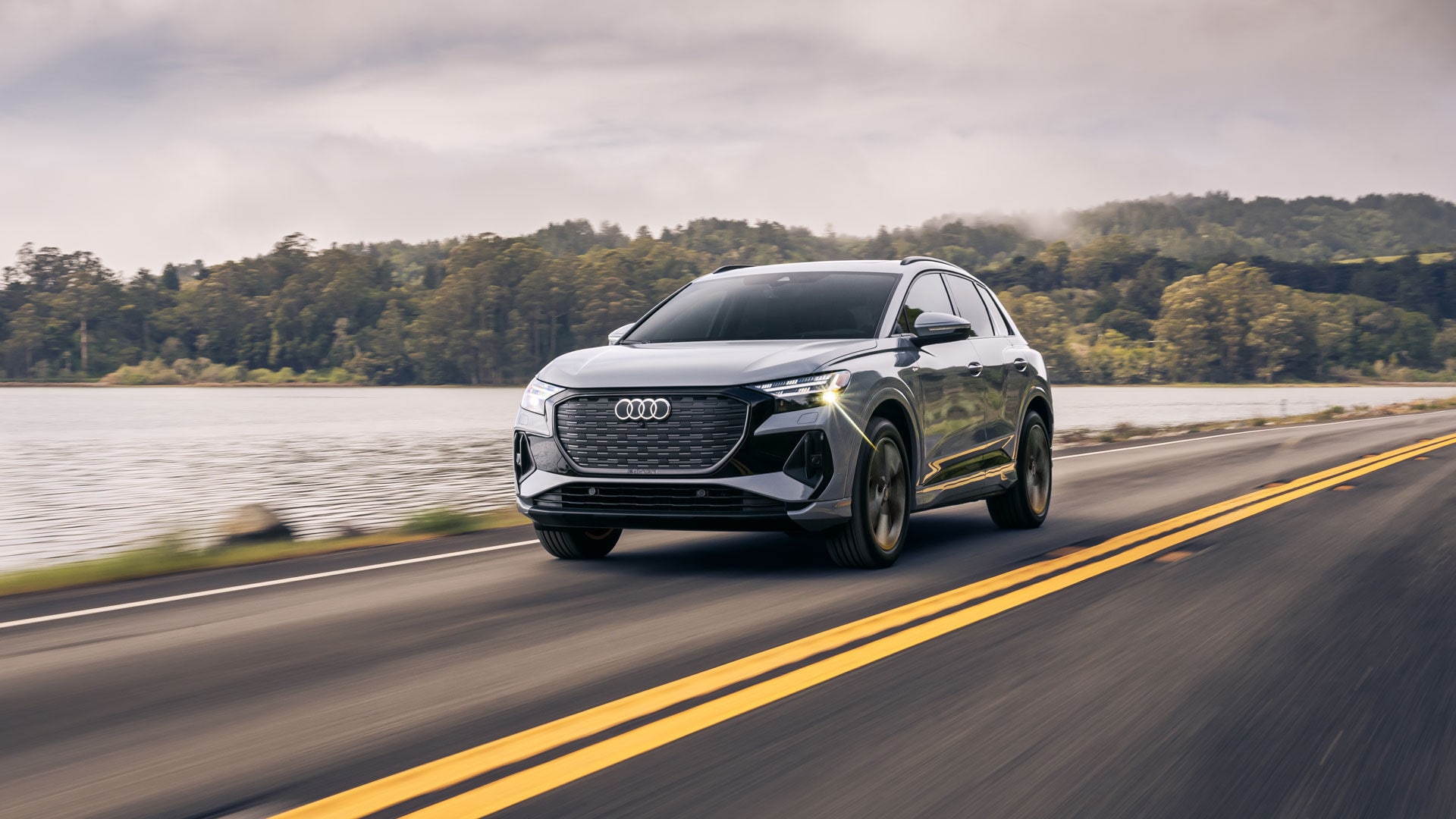 Vue 3/4 avant de l'Audi Q4 e-tron 2025 roulant sur une route.