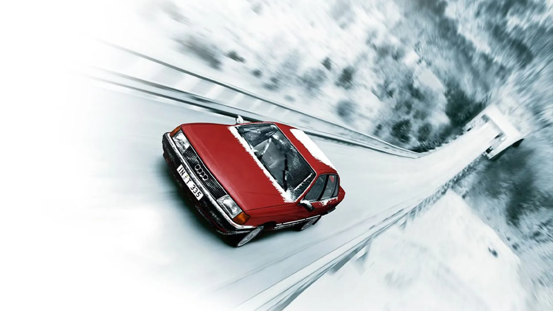 Audi quattro rouge roulant sur une route enneigée, démontrant l’efficacité de la transmission intégrale en conditions hivernales.