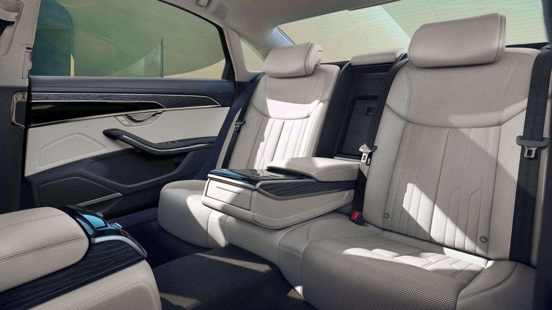 Sièges arrière de l’Audi A8 2025 en cuir beige avec accoudoir central, finitions bois noir et design luxueux de l’habitacle.