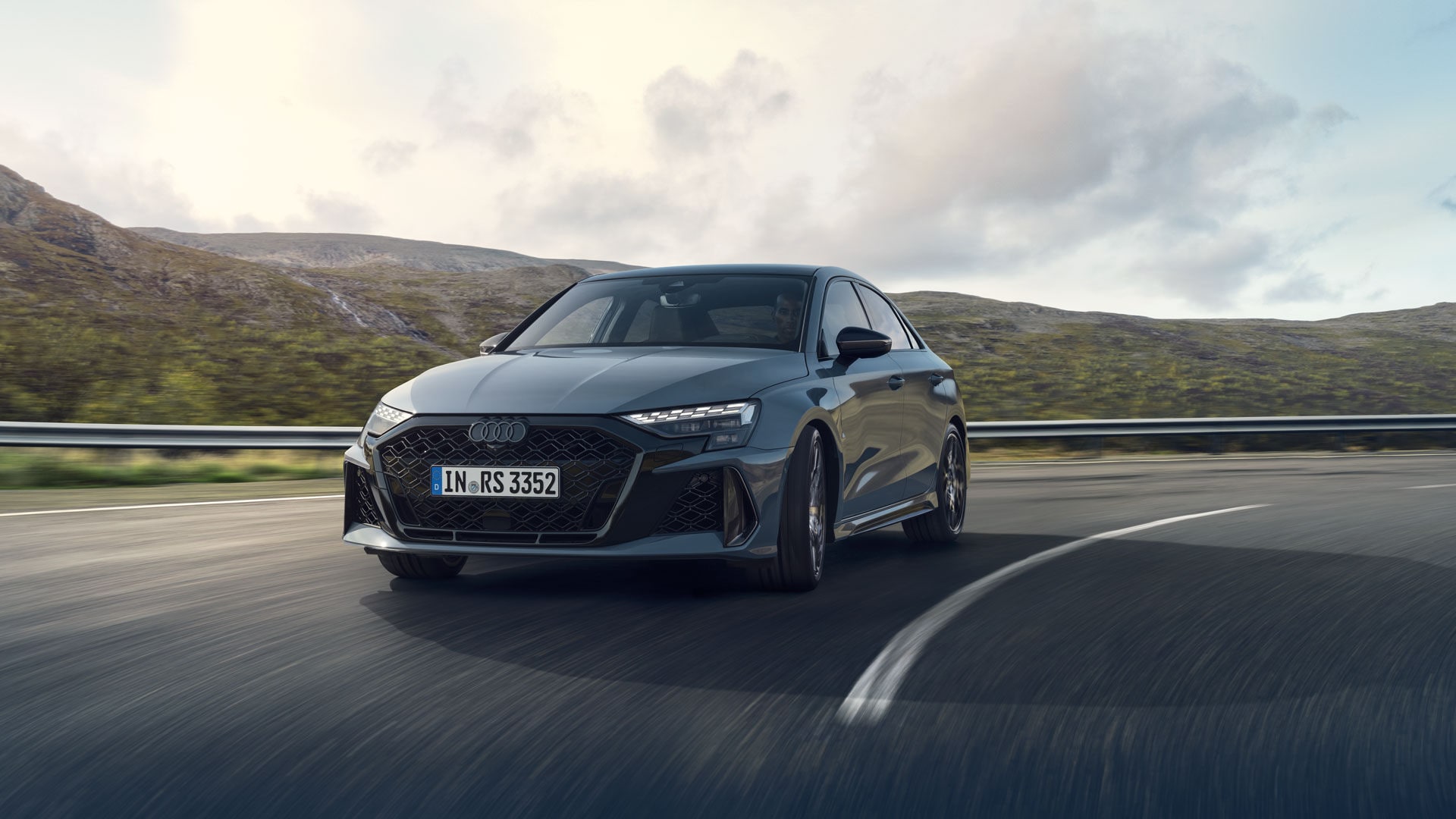 Vue 3/4 avant de l'Audi RS 3 2025 roulant sur une route.