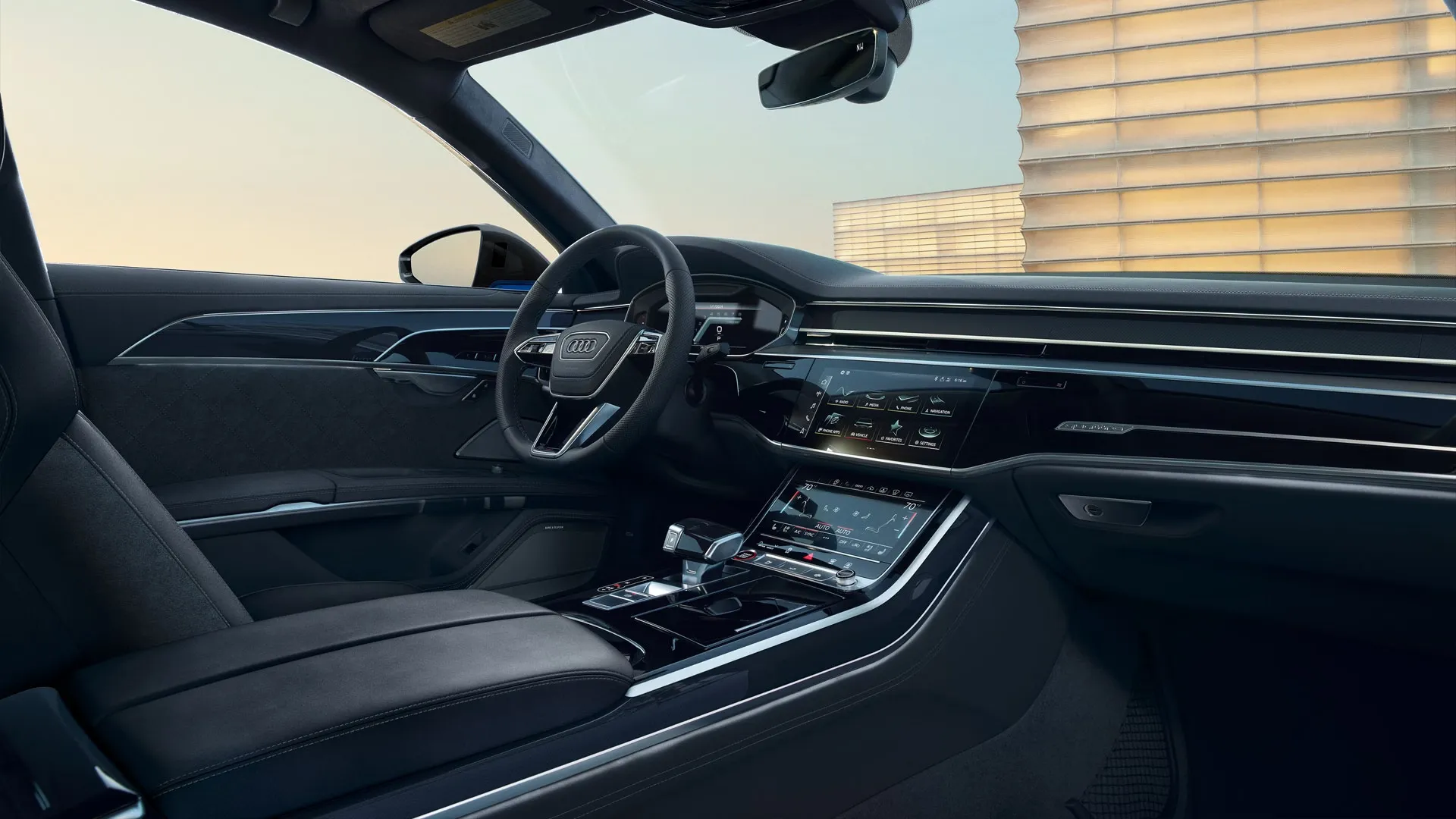 Vue de l’habitacle avant de l’Audi S8 2025 noir, volant sport, écrans tactiles MMI et garnitures aluminium.