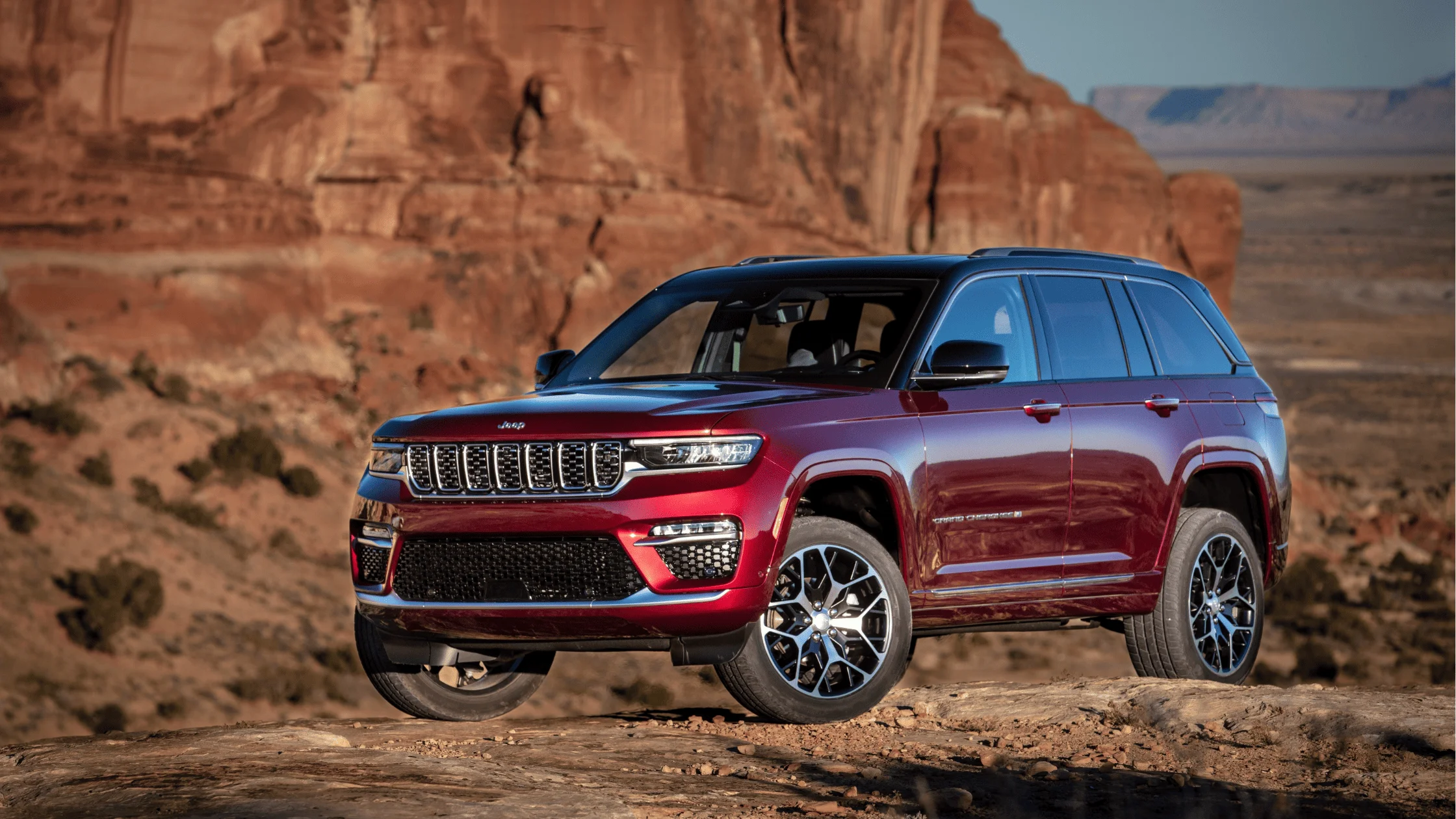 The 2025 Jeep® Grand Cherokee parked in front of stunning rock formations, highlighting its rugged design and adventure-ready features.