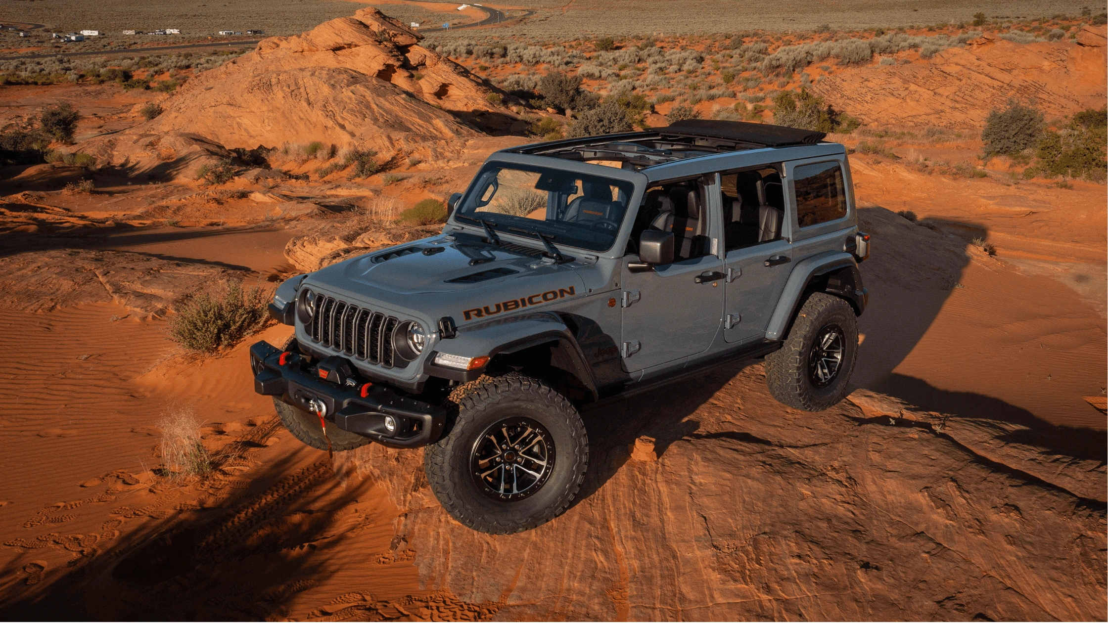 A rugged 2025 Jeep® Wrangler Rubicon navigating through red desert terrain in Fort Myers, FL.