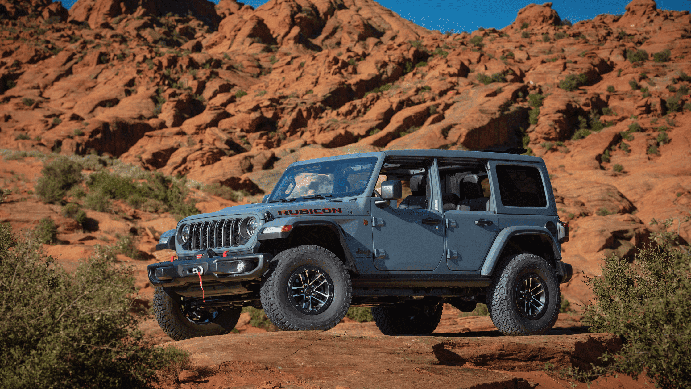 2024 Jeep® Wrangler Rubicon navigating rugged red rock terrain near Naples, FL, highlighting the off-road capabilities and superior performance in challenging environments.