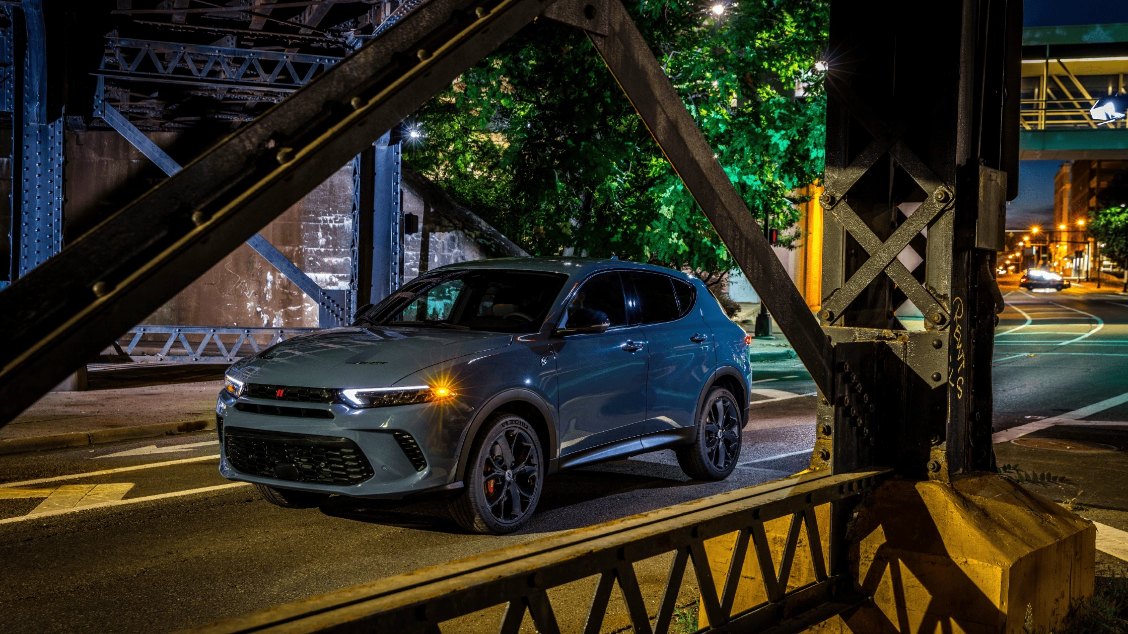 2024 Dodge Hornet parked under an urban bridge at night, highlighting its sleek design and customization options for Fort Myers drivers.