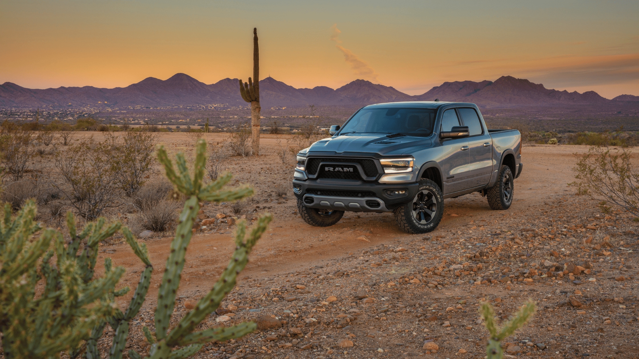2024 Ram 1500 parked in a rugged desert landscape during sunset, showcasing its durability and off-road capability, perfect for Fort Myers lifestyles.