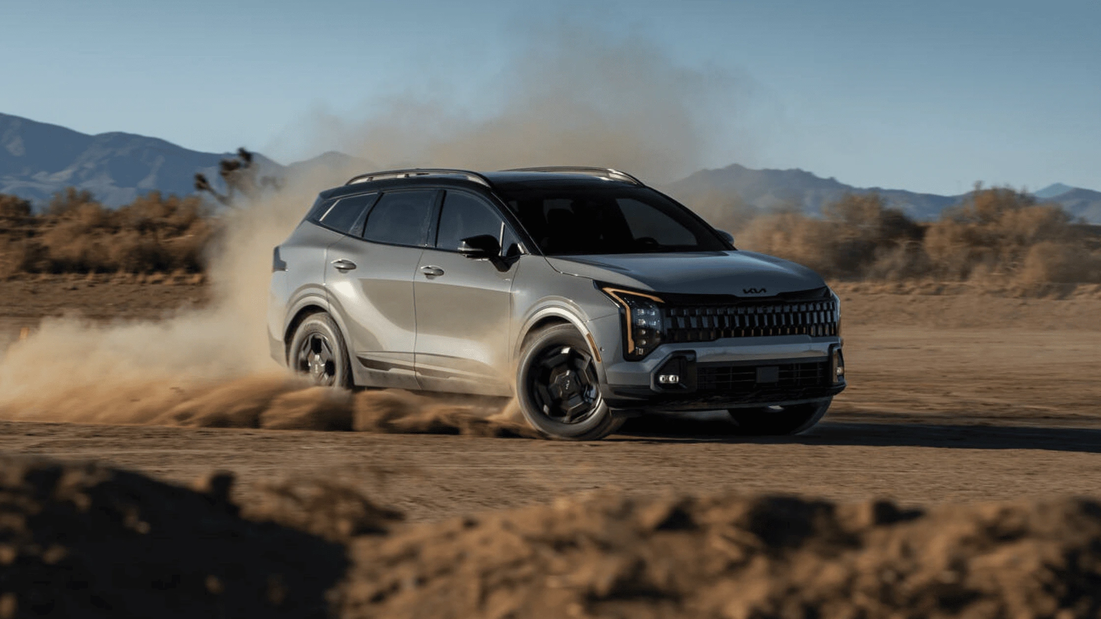  2026 Kia Sportage kicking up dirt off-road near Fort Myers, highlighting its performance in rough terrain.