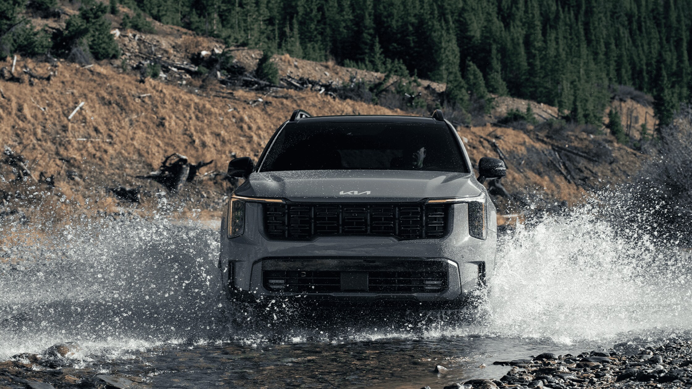 2024 Kia Sorento SUV driving through water on a rugged terrain near Port Charlotte, FL, highlighting its off-road capabilities and family-friendly design.