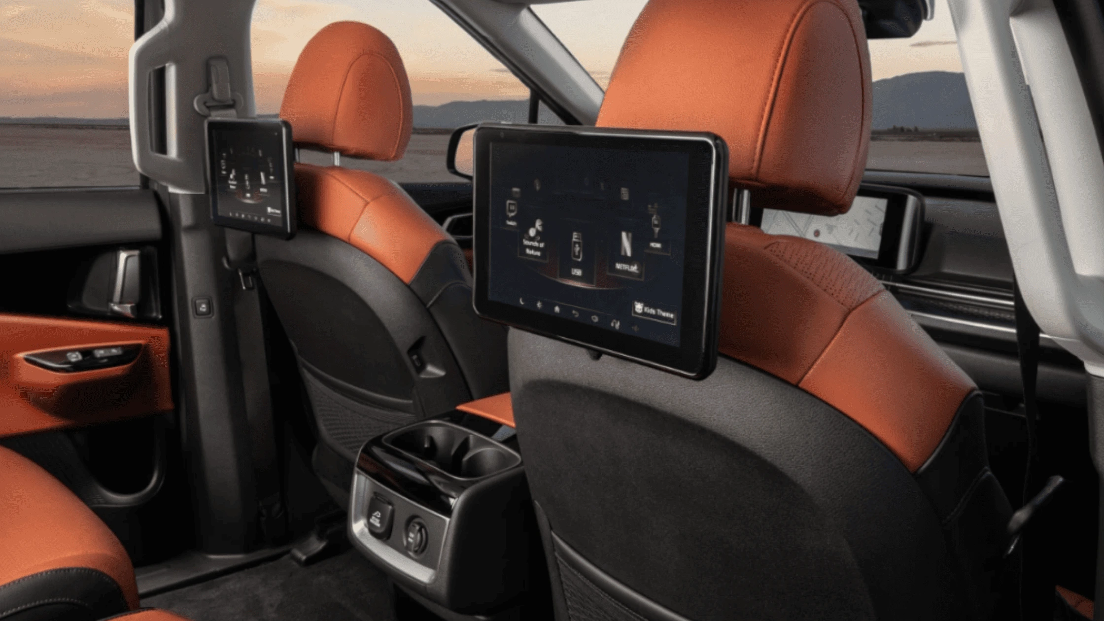Rear seat entertainment screens in the 2024 Kia Carnival, showcasing advanced in-car technology and spacious comfort for passengers, near Naples, FL.