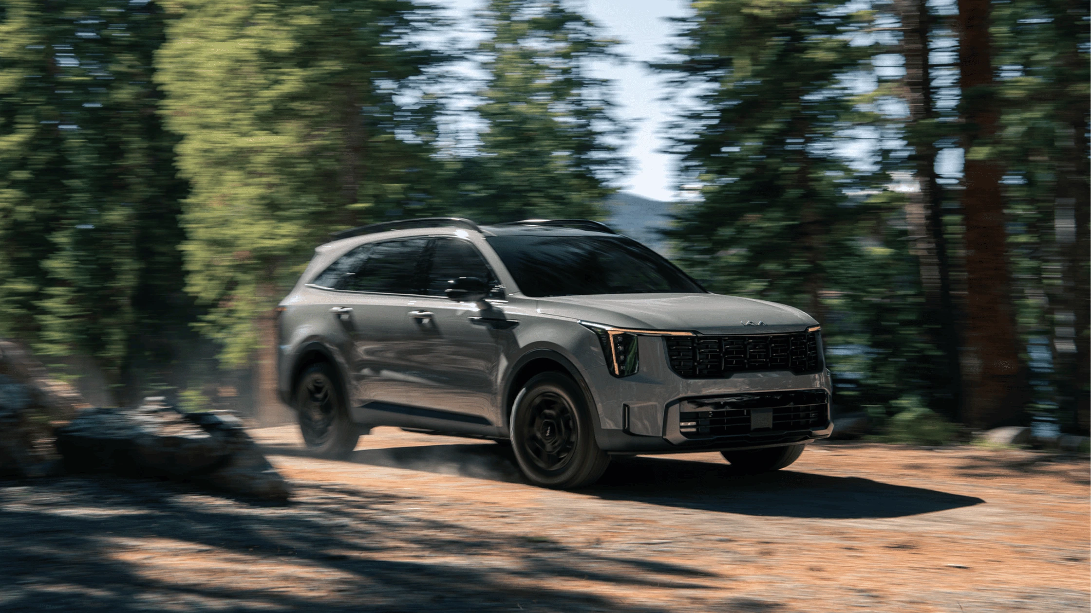 The 2025 Kia Sorento showcasing its striking design while navigating through a wooded trail in Fort Myers.