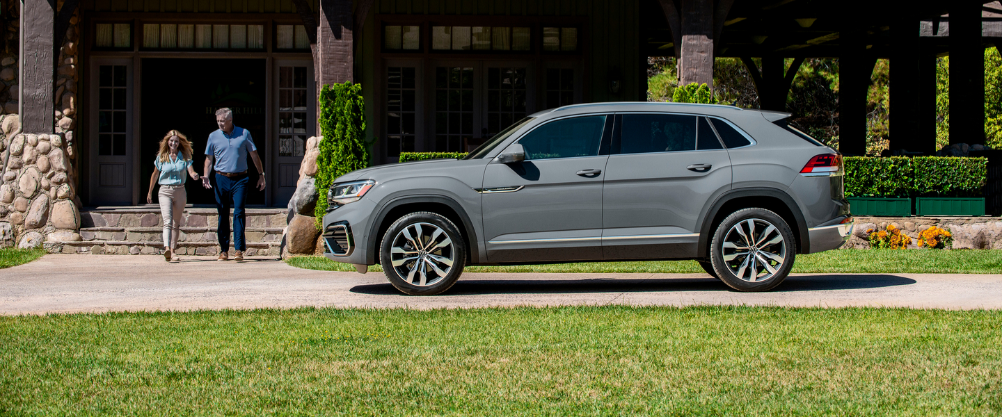 Couple walking next to a grey Volkswagen