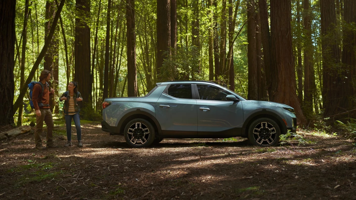 2026 Hyundai Santa Cruz in a forest with two people