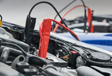 jumper cables connected to car batteries