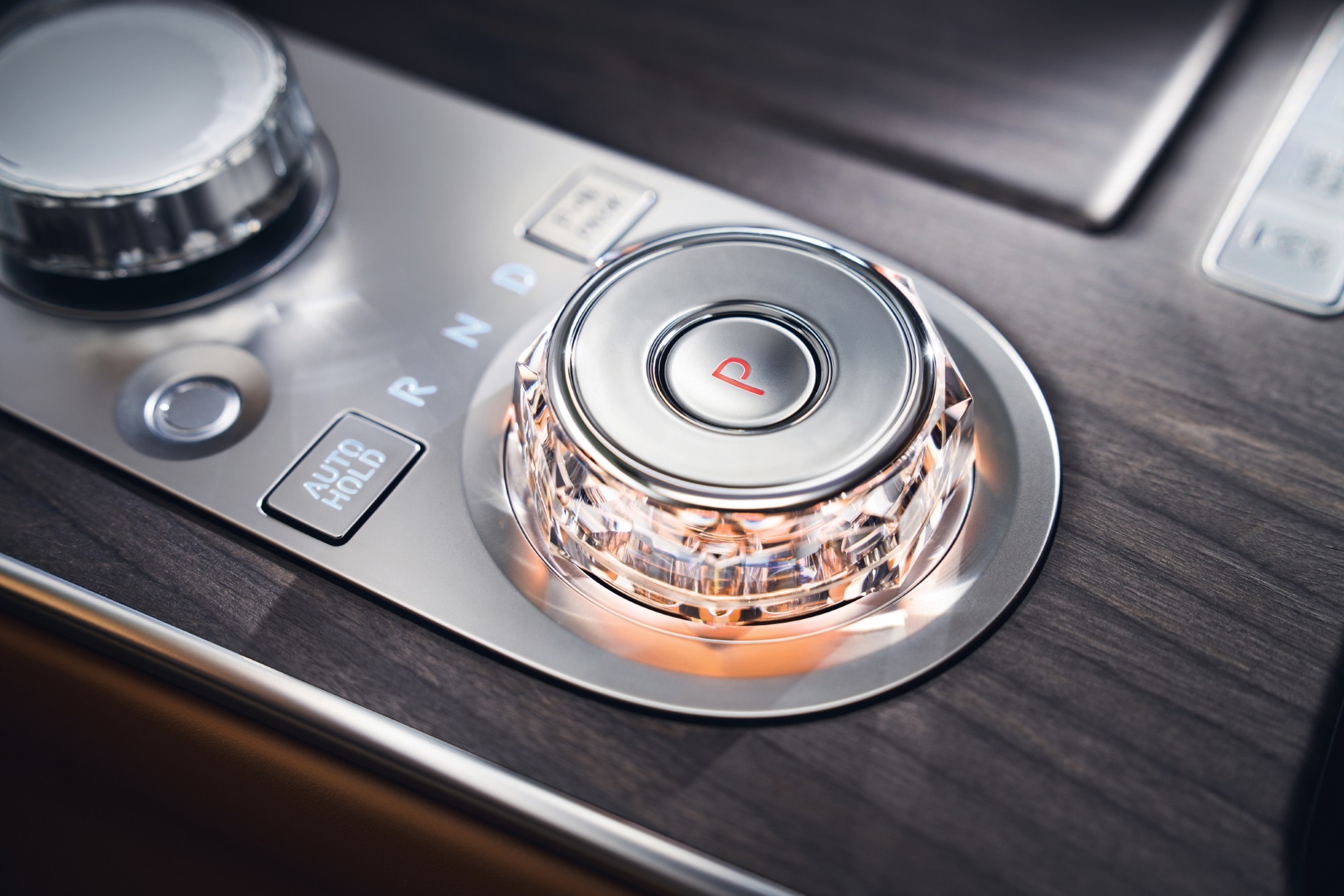 Interior close up shift by wire gear selector wheel with red ambient light inside the Genesis G80