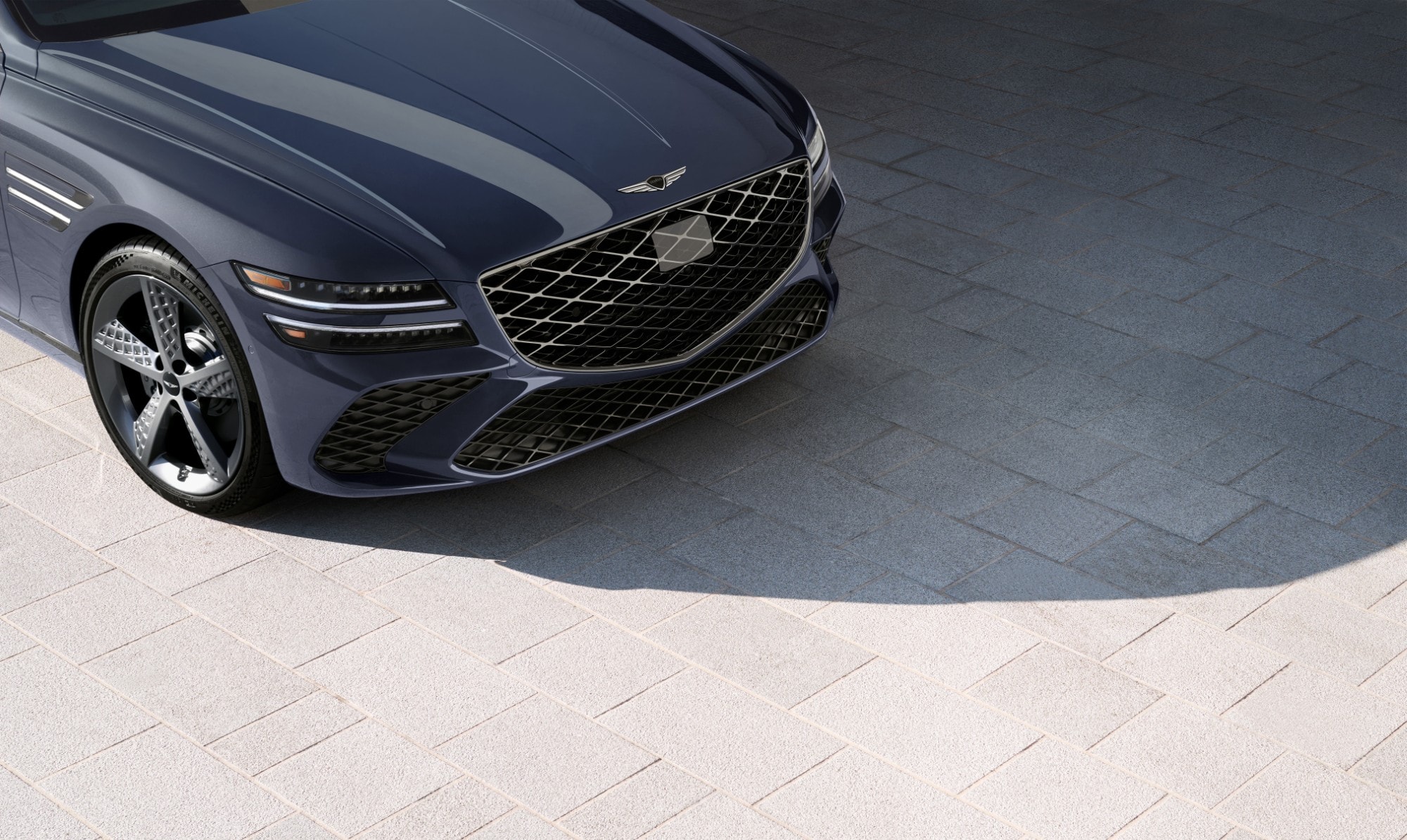 3/4 passenger side close up of wheel details on Genesis G80 in Ceres Blue