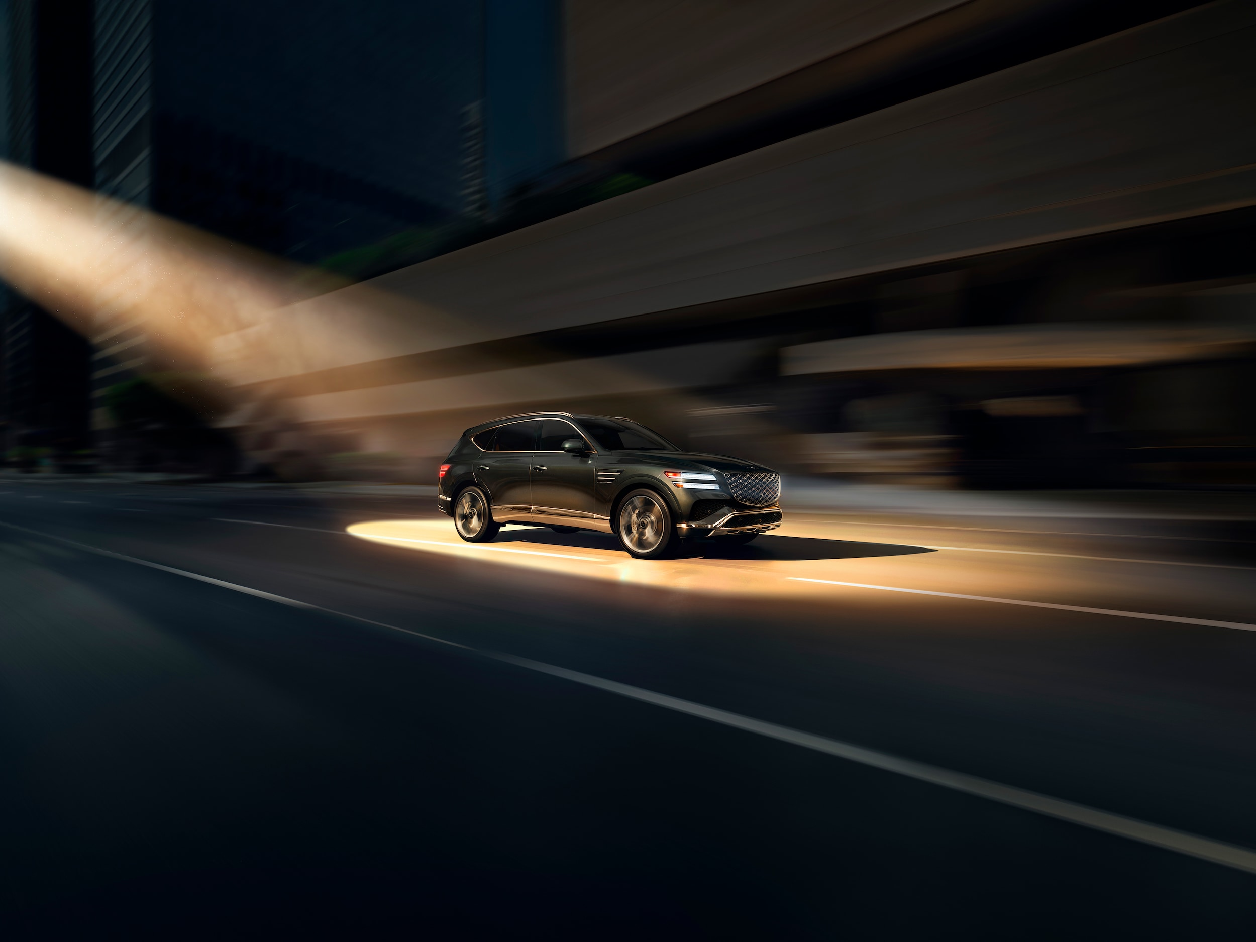 Genesis GV80 driving through city at night