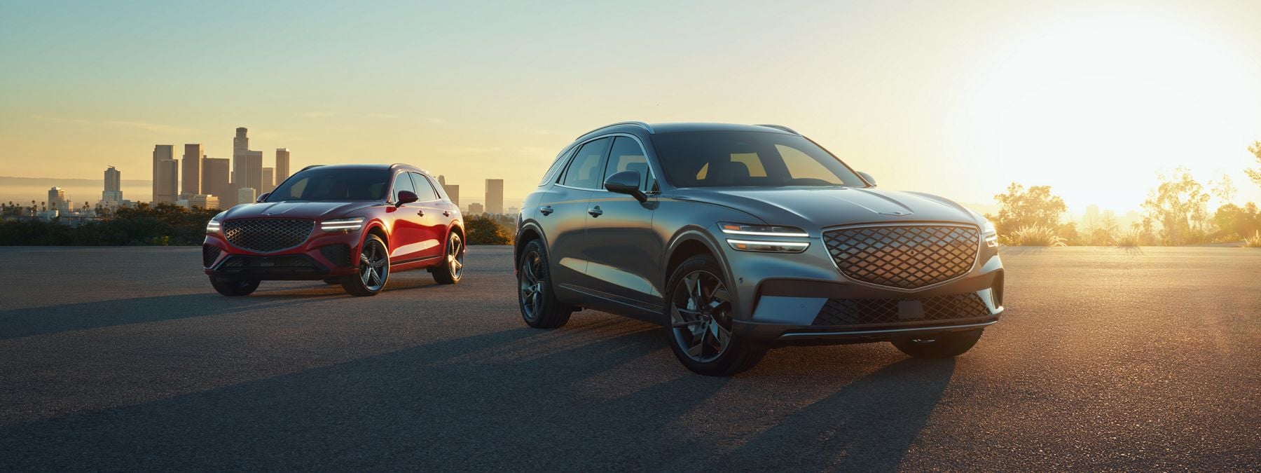 A pair of new Genesis SUVs in the sunset