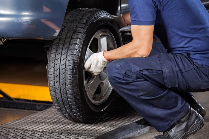 Genesis service technician working on a tire