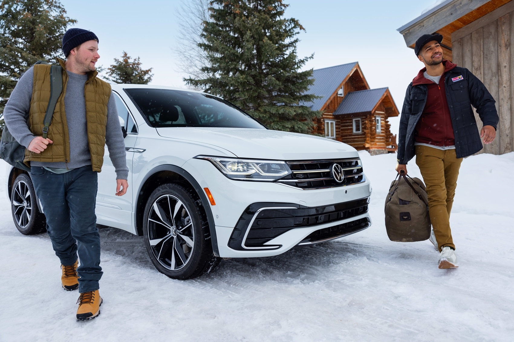 Volkswagen Tiguan parked in the snow while two men walk out of vehicle on each side holding bags from Volkswagen Dealer near Caldwell NJ