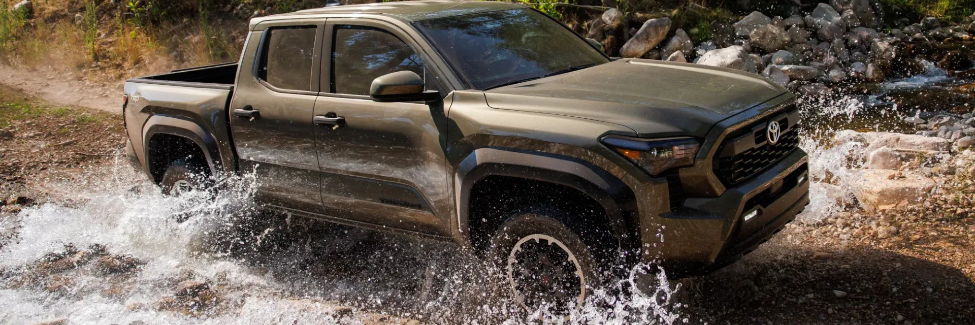 Toyota Tacoma driving off-road through water