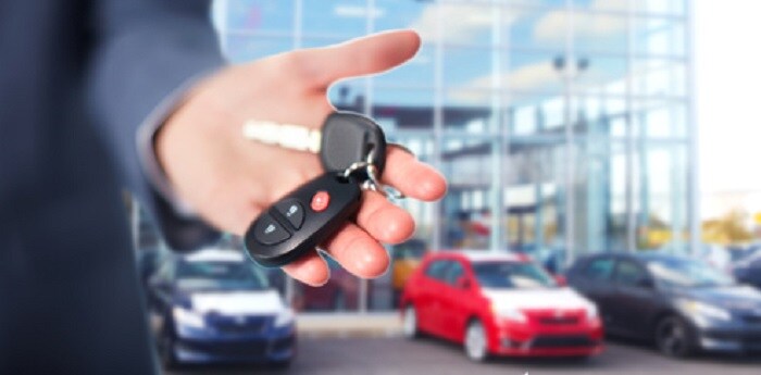 Man_Holding_Keys_In_Front_of_Dealership.jpg