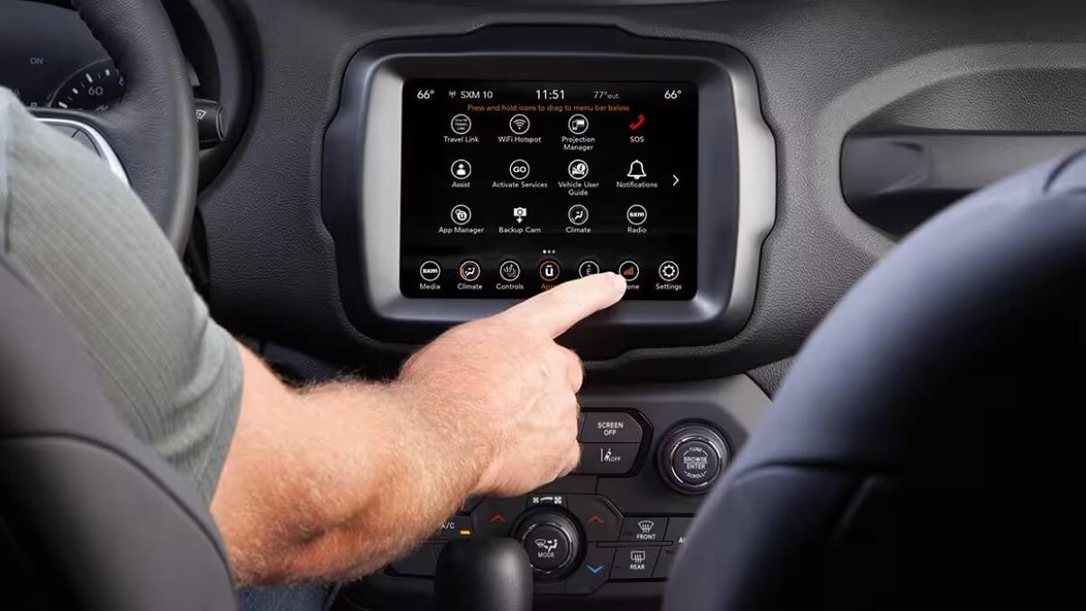 Interior shot of the Jeep Renegade dashboard where an adult male
is using the touchscreen to access the Renegade's infotainment
system.