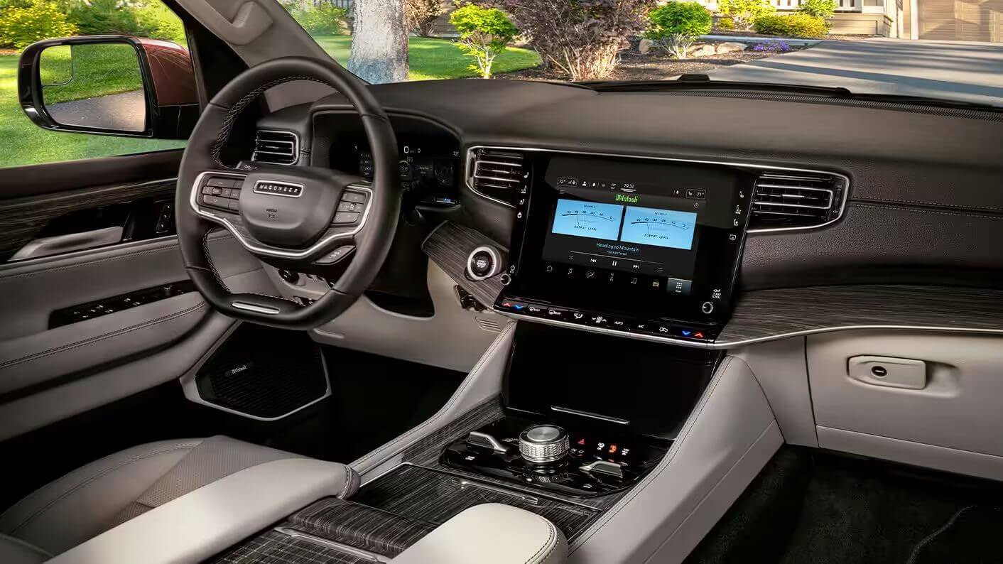 Interior shot of the Wagooneer steering wheel, touchscreen, and dashboard.
