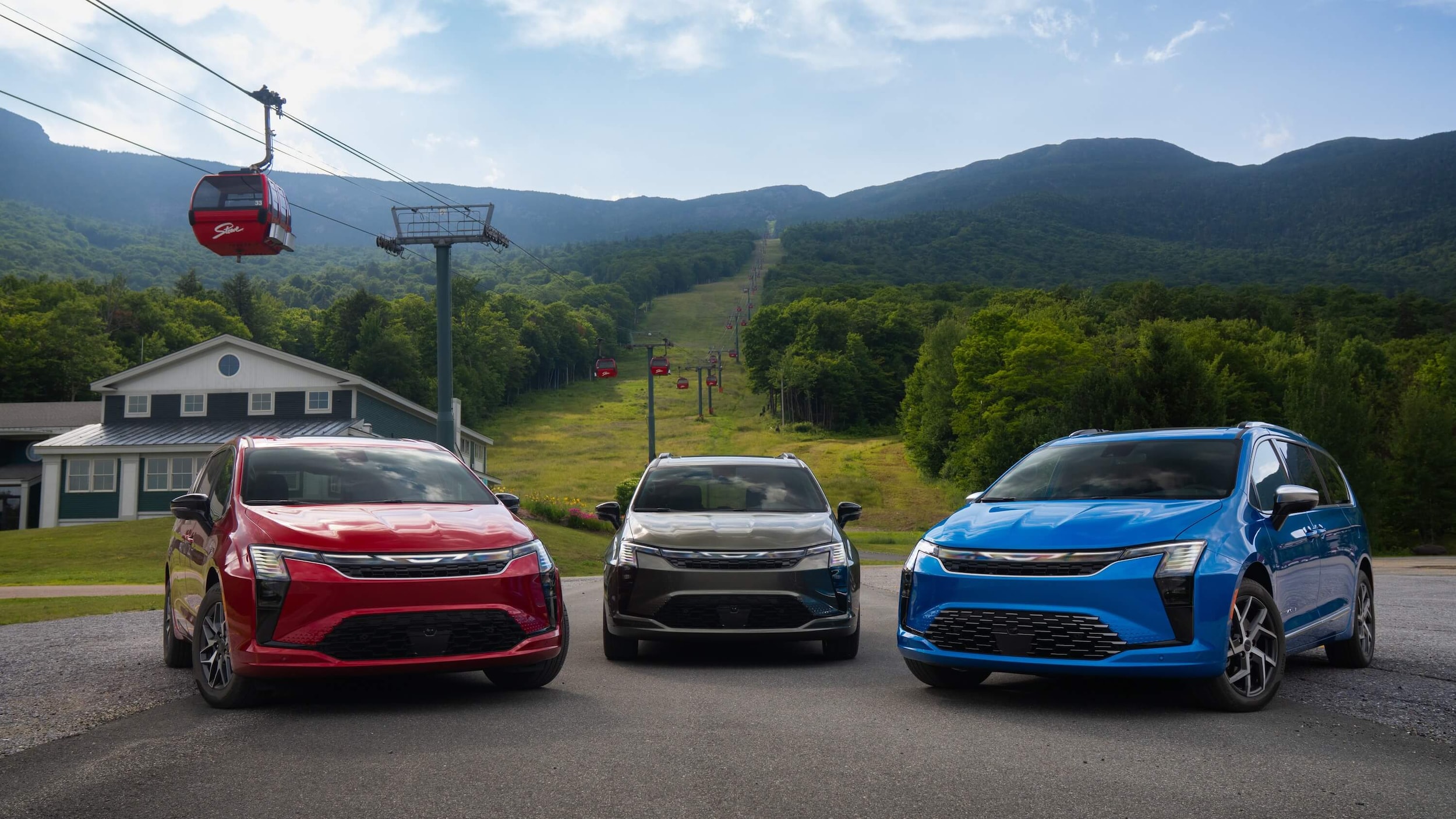 Three Chrysler Pacifica minivans lined up with Red Hot, Olive Green, and Hydro Blue