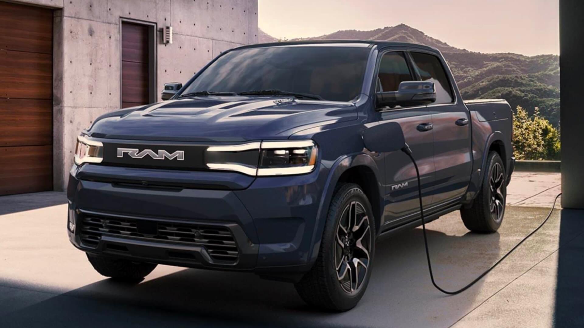 RAM 1500 REV plugged in and charging outside an infustrial style home. Mountainous terrain can be seen in the background.