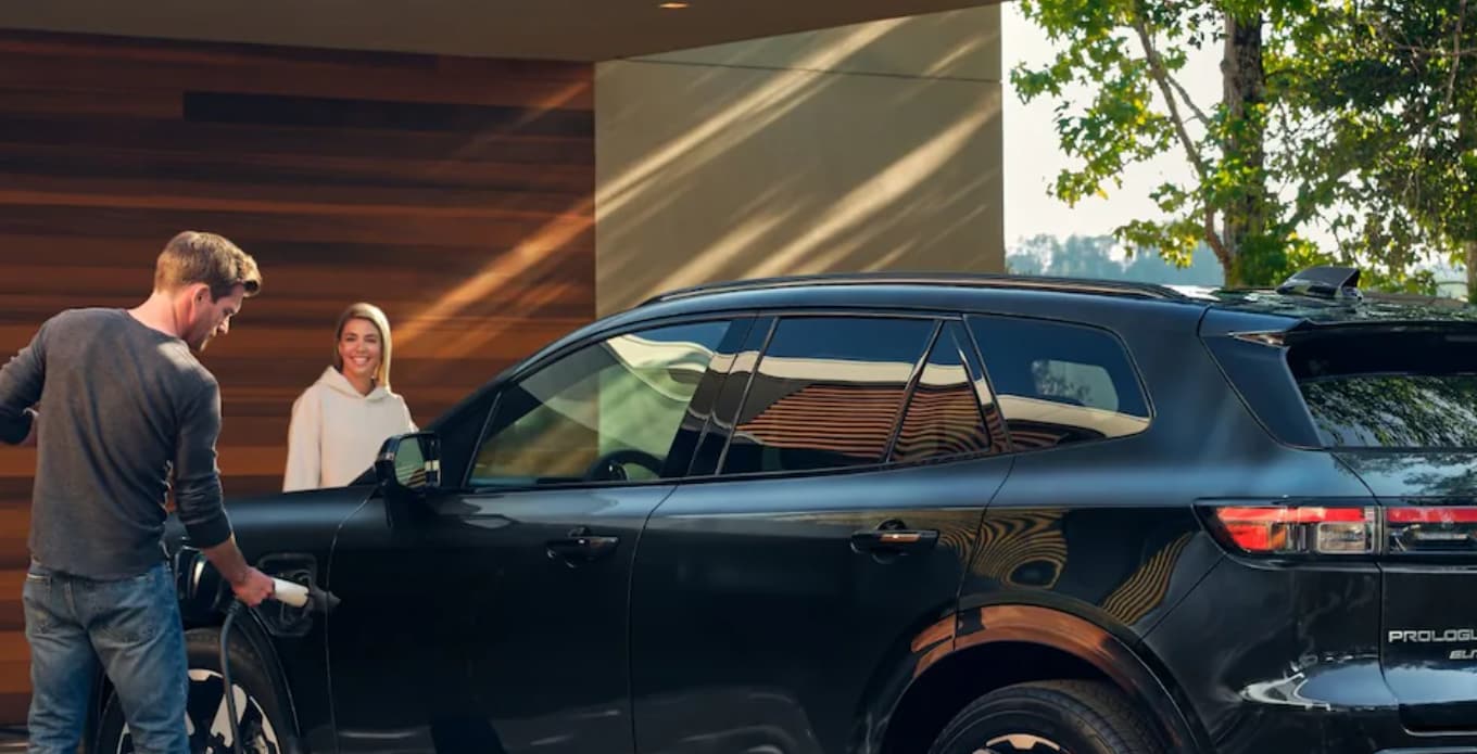 Two people charging a Honda Prologue