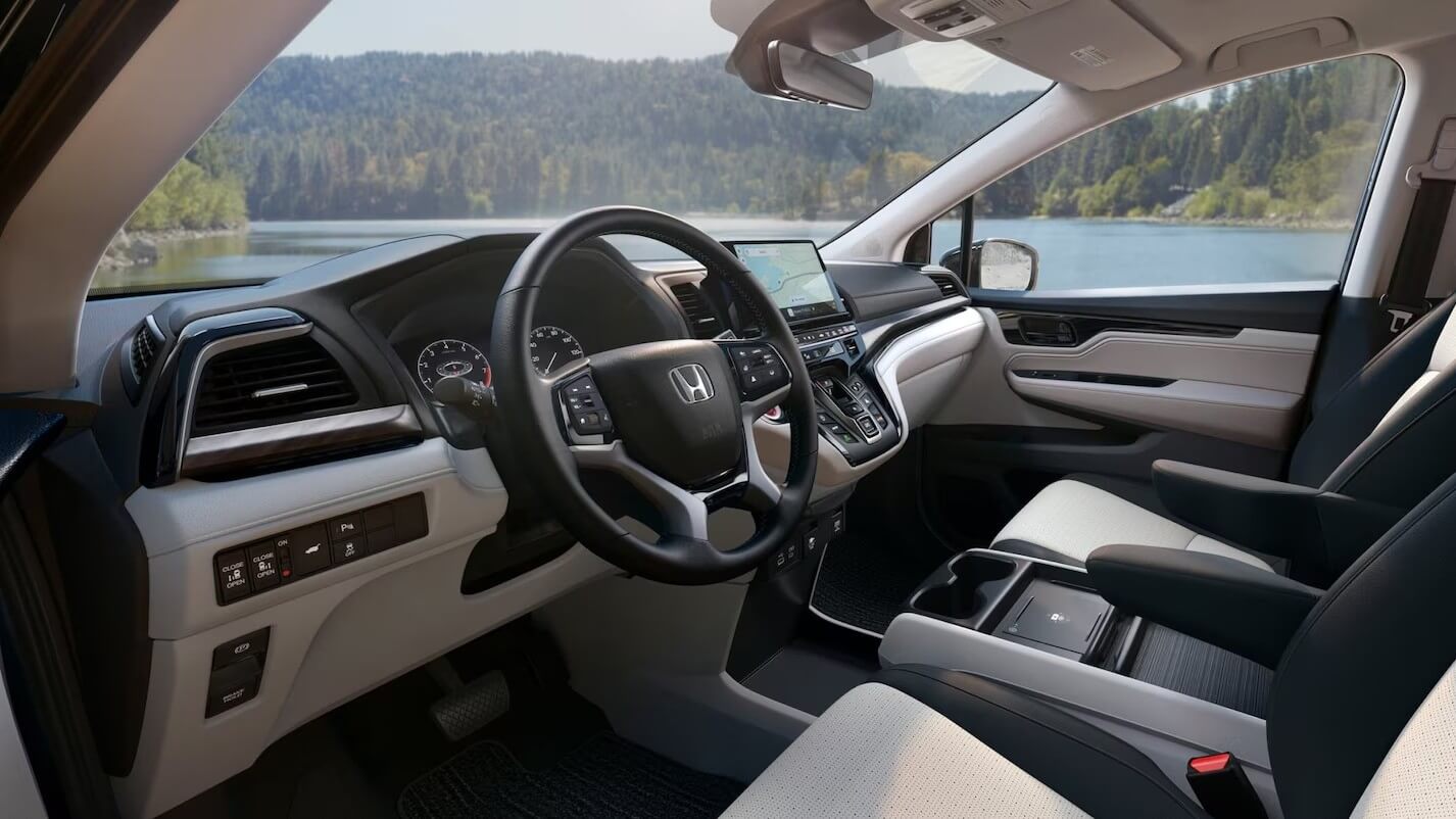  The front seats, steering wheel, and center console of a Honda Odyssey