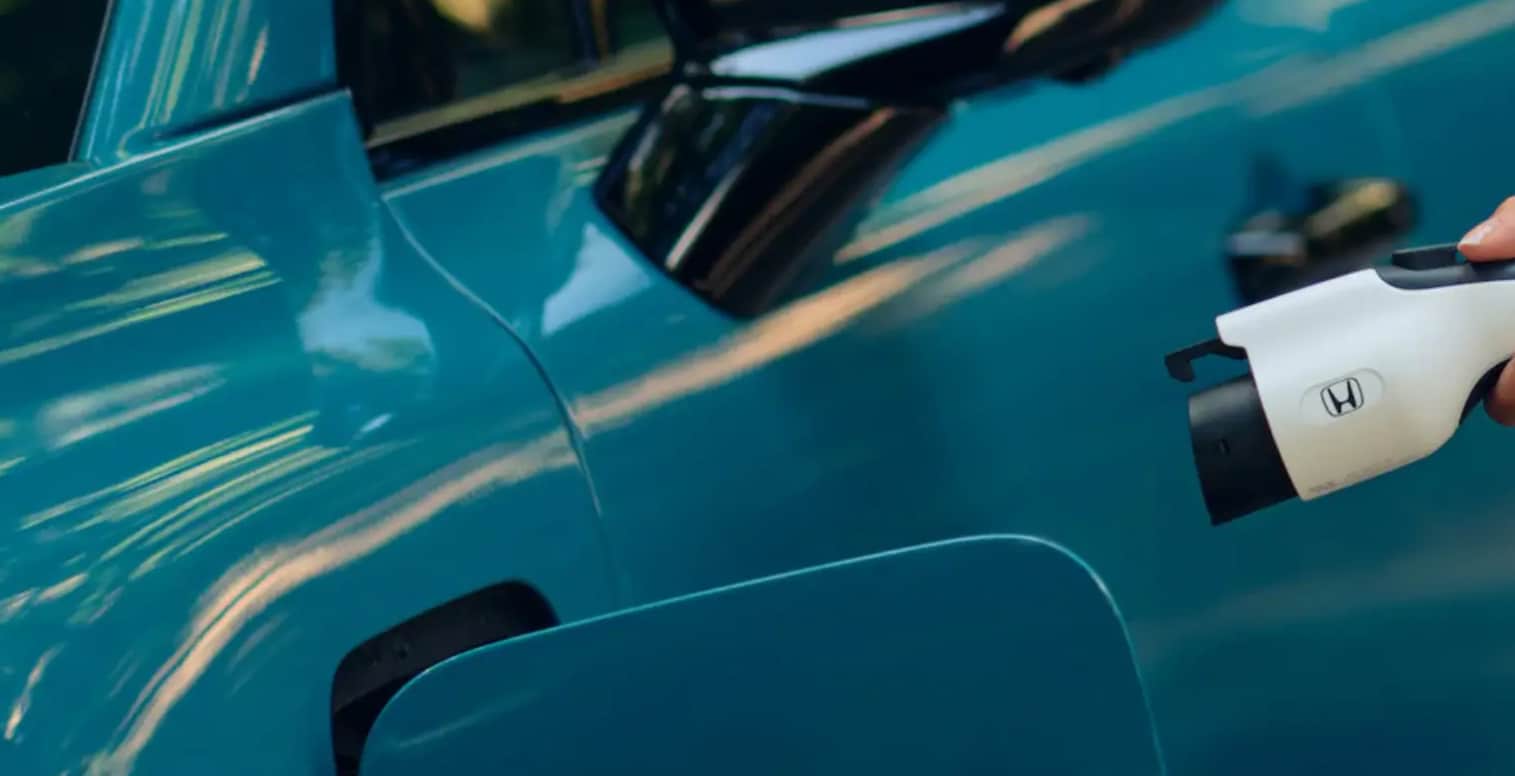 An image showing someone charge the Honda Prologue