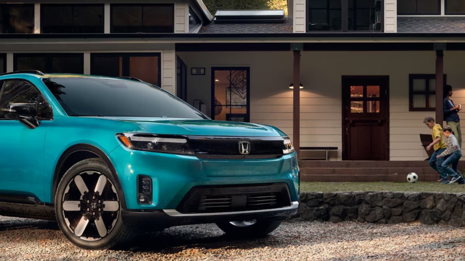 Family enjoying an evening outdoors while a Honda Prologue is charged
