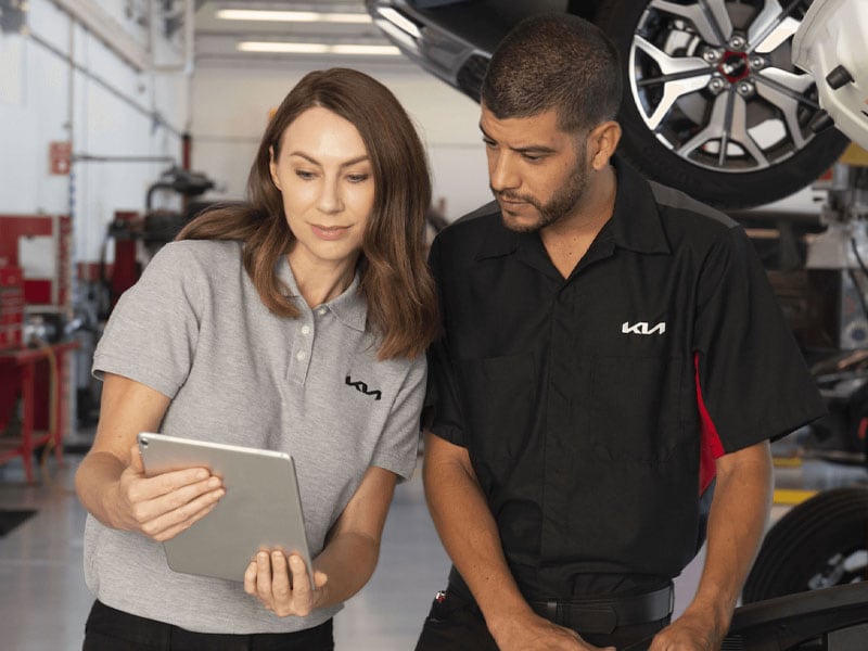 Go Kia Renton service advisor and technician reviewing a vehicle inspection
