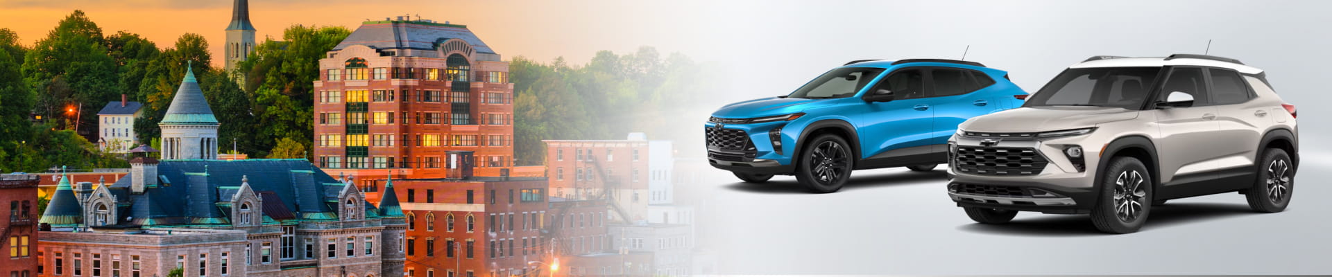 Two Chevrolet SUVs displayed beside a scenic downtown cityscape at sunset.