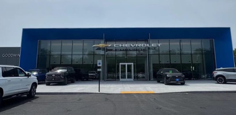 Front exterior view of Goodwin Chevrolet dealership with parked Chevy SUVs on an asphalt lot.