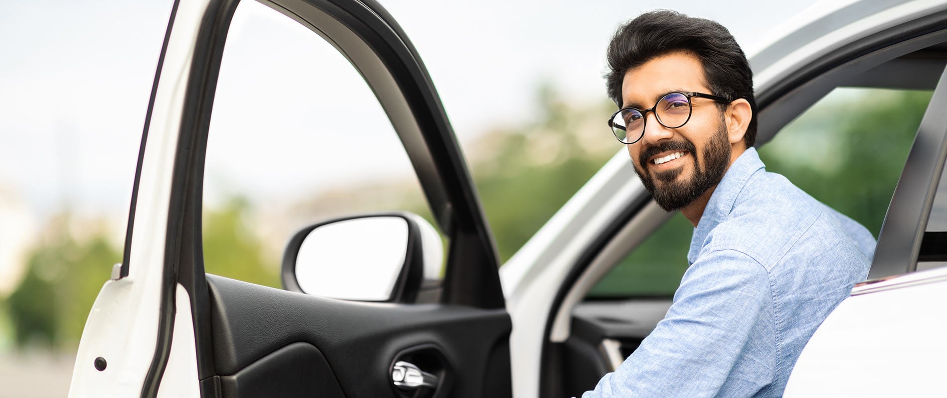 A man getting into a white car