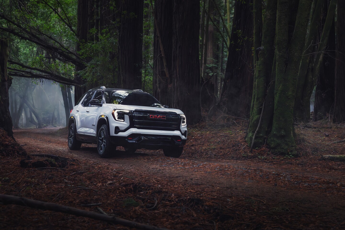 New GMC Terrain on a dirt road with mountains in the background.