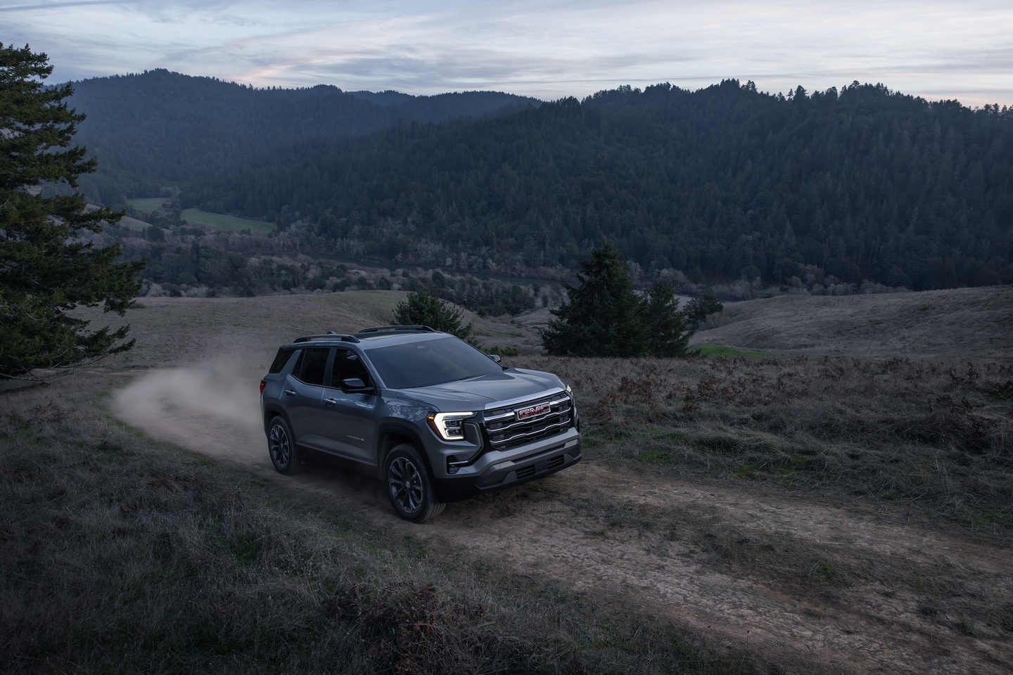 New GMC Terrain on a dirt road with mountains in the background.