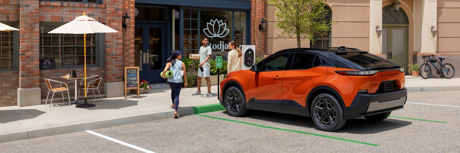 Subaru Uncharted electric SUV charging in a parking spot outside of a yoga studio