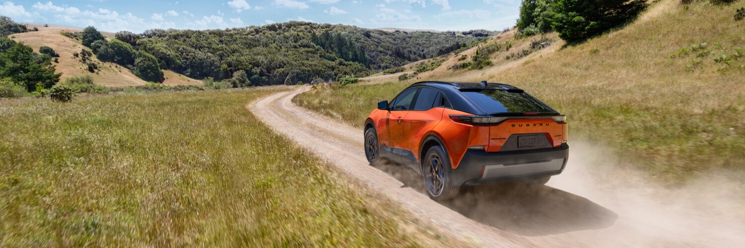 habanero orange Subaru Uncharted SUV driving on a dirt road