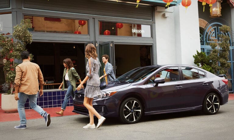 2021 Subaru Impreza exterior parked outside restaurant with friends walking in