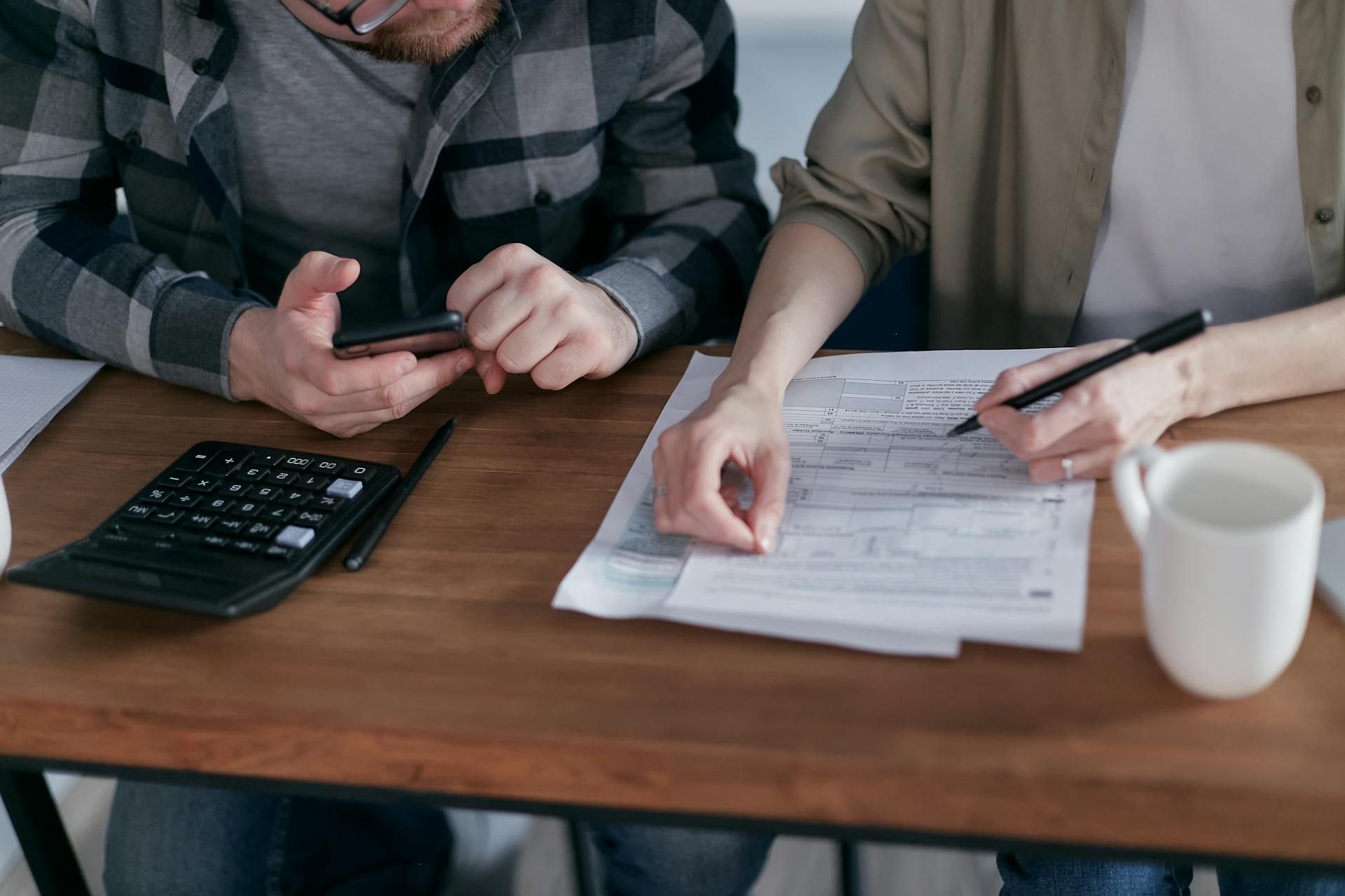 A couple using a calculator and going over paperwork