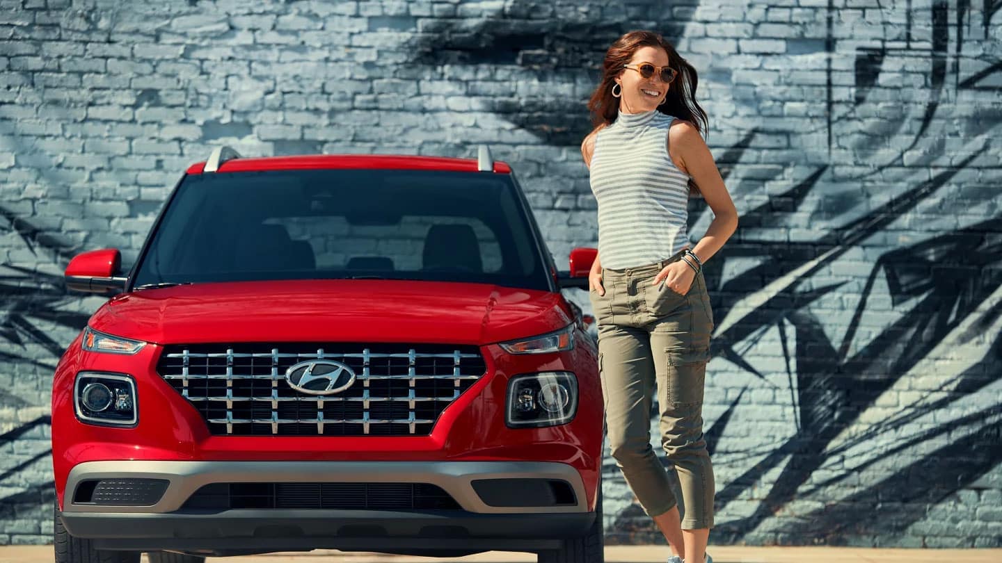 A woman standing next to her Hyundai Venue
