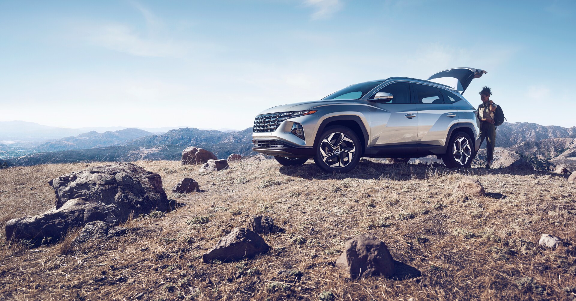 The Hyundai Tucson with the Tailgate up and a person nearby