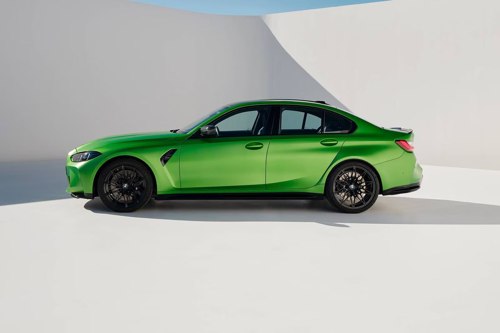 A green bmw m3 sitting parked.