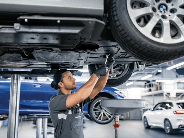 A man changing fuids of a vehicle.