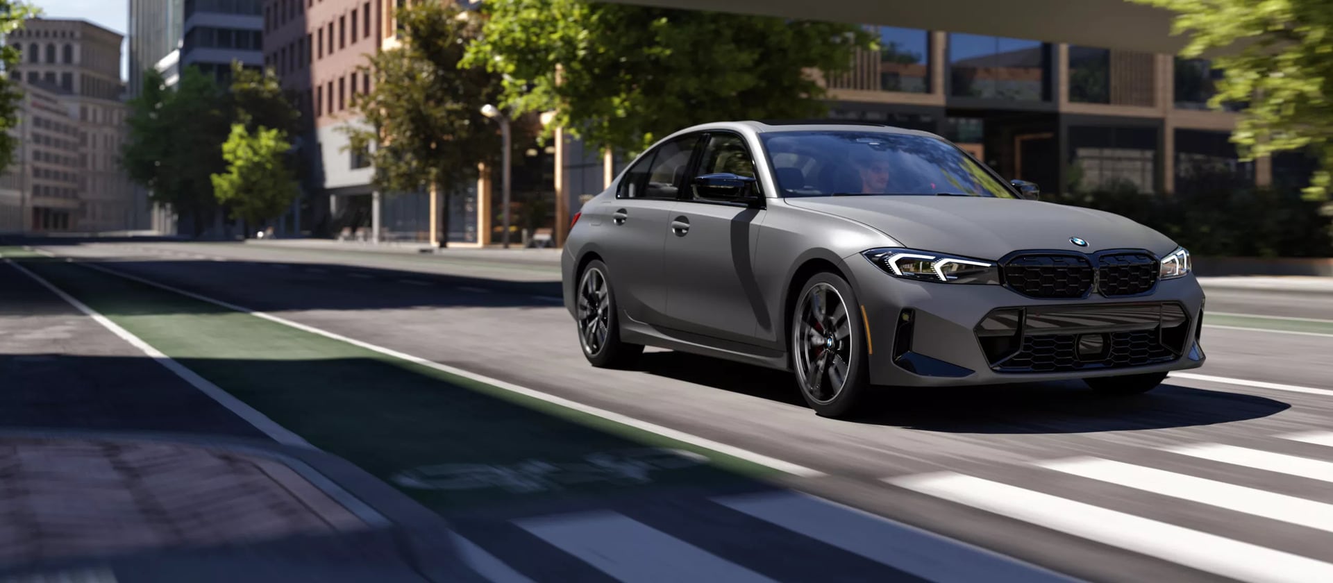 A silver bmw 340i driving on the road.